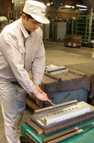 A craftsman performing scraper fabrication